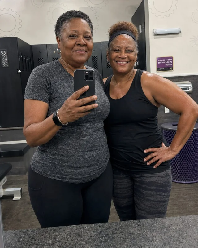 Denise standing beside another woman in a gym after building a consistent fitness routine